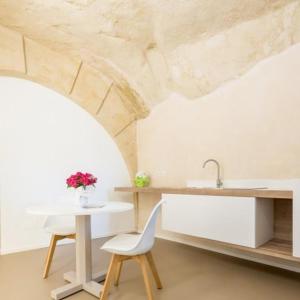 a kitchen with a sink and a table and chairs at Al Vico in Matera