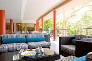 a restaurant with couches and a table with food on it at SunSquare Cape Town Gardens in Cape Town