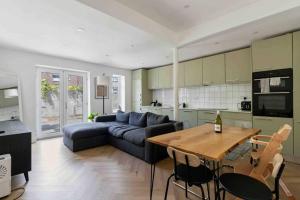 uma sala de estar com um sofá azul e uma mesa em Modern 3 Bed Apartment in Tottenham em Londres