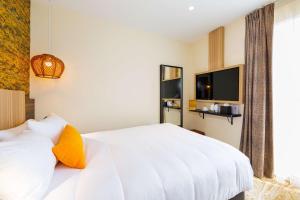 a bedroom with a white bed and a television at Best Western Mulhouse Salvator Centre in Mulhouse