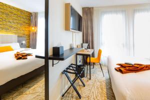 una camera d'albergo con 2 letti e una scrivania di Best Western Mulhouse Salvator Centre a Mulhouse