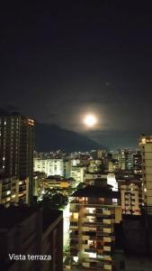 una vista de una ciudad por la noche con la luna en Contemporary, en Caracas