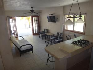 a kitchen and living room with a table and chairs at Villas Del Mar in Celestún