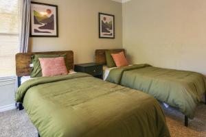 1 dormitorio con 2 camas con colchas verdes y ventana en Casino Cottage Getaway 4 Mi to Choctaw Casino!, en Durant