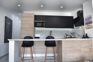 a kitchen with a counter and two bar stools at Ke Casetta Tenerife Anna Apartment in Adeje