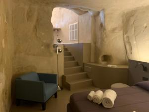 a bedroom with a bed and a chair and stairs at Al Vico in Matera