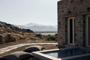 a stone building with a hot tub with a view at Naxian Rhapsody in Stelida