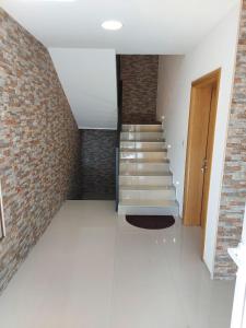 a room with stairs and a brick wall at Apartmani Milina in Lepterija