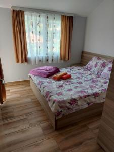 a bedroom with a bed with red shoes on it at Apartmani Milina in Lepterija