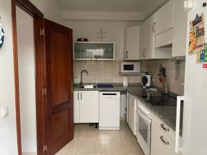 a kitchen with white cabinets and a sink at Apartamento casa típica canaria in Playa Honda