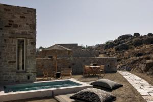 a stone house with a swimming pool and a table at Naxian Rhapsody in Stelida