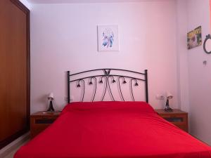 a bedroom with a red bed with two night stands at Apartamento casa típica canaria in Playa Honda