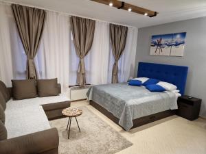 a bedroom with a blue bed and a couch at Green life, Bansko, private studio c-17 in Bansko