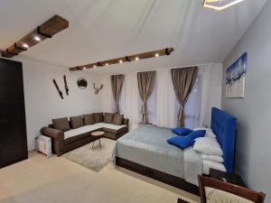 a bedroom with a bed and a couch at Green life, Bansko, private studio c-17 in Bansko
