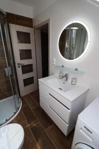 a white bathroom with a sink and a mirror at Apartmány Karolína - Kašperské Hory in Kašperské Hory