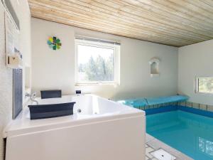 baño con bañera y piscina en 10 person holiday home in Bl vand, en Ho