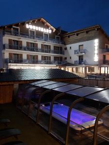 a hotel with a swimming pool at night at Hôtel L'Oustalet in Font-Romeu-Odeillo-Via