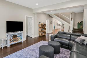 uma sala de estar com um sofá de couro e uma televisão de ecrã plano em Sanford Serenity em St. Augustine