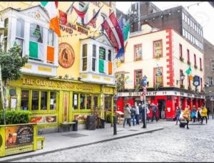 a city street with buildings and people walking on the street at Cosy Cottage in the City in Dublin