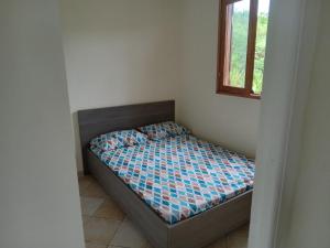- un petit lit dans une chambre avec fenêtre dans l'établissement Maison zebre, à Port-Louis