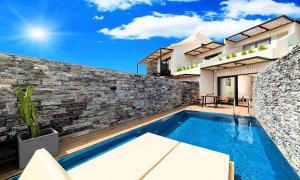 een villa met een zwembad en een huis bij Aelia Suites in Agios Nikolaos
