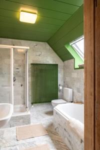 a bathroom with a tub and a toilet and a sink at Au cœur des champs - Gîte in Nivelles