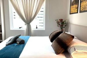 1 dormitorio con cama con almohadas y ventana en 904 - Flat Studio Consolação Premium Elegance, en São Paulo