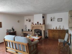 a living room with a fireplace and a table and chairs at Casa do Lagar in Almeida