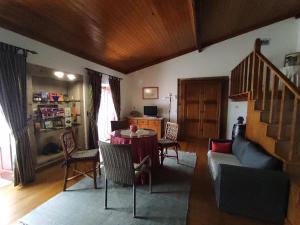 a living room with a table and chairs and a staircase at Casa do Lagar in Almeida