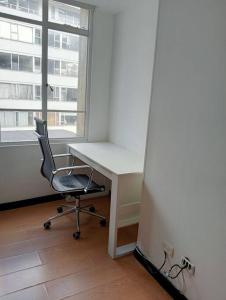 una oficina con escritorio, silla y ventana en Apartamento Continental, en Bogotá