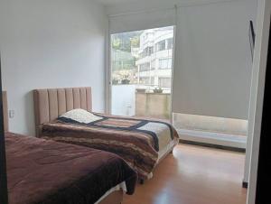 1 dormitorio con 2 camas y ventana grande en Apartamento Continental, en Bogotá