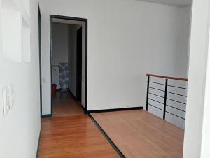 a hallway with a room with white walls and wood floors at Apartamento Continental in Bogotá