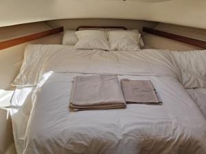 ein weißes Bett mit zwei Handtüchern darüber in der Unterkunft Huifeng Chen in Lissabon