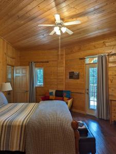 1 dormitorio con 1 cama y ventilador de techo en Sundance Country Lodge B&B en Marlboro