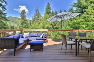 a patio with a couch and a table and an umbrella at Leavenworth Cabin 3 Mi to Lake Wenatchee Hot Tub! in Leavenworth