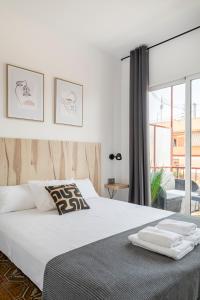 1 dormitorio con cama blanca y ventana grande en CASA MILA SV19 guesthouse, en Alicante
