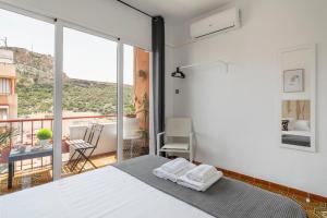 1 dormitorio con 1 cama y balcón en CASA MILA SV19 guesthouse, en Alicante