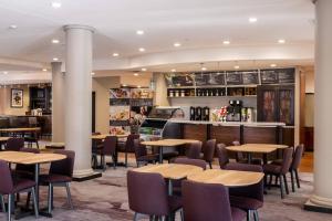 a restaurant with tables and chairs and a bar at Courtyard by Marriott Newark-University of Delaware in Newark