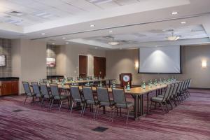 Courtyard by Marriott Newark-University of Delaware في نيوارك: قاعة المؤتمرات مع طاولة وكراسي طويلة