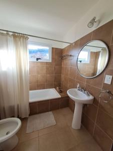 a bathroom with a tub and a sink and a mirror at Ventanas de la Patagonia 2 in Esquel +23 photos