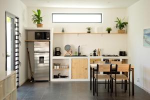uma cozinha com uma mesa e cadeiras e um frigorífico em Maison Moderne et Cosy proche de Papeete em Punaauia