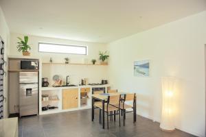 uma cozinha com mesa e cadeiras num quarto em Maison Moderne et Cosy proche de Papeete em Punaauia