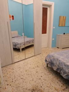 a bedroom with two beds and a mirror at Il Maestrale in Sava