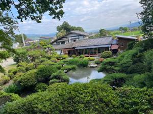 a house with a pond in a garden at 離れの宿　かぶろの庭 in Matsukawa