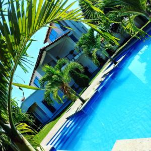 a resort with palm trees and a swimming pool at Cabaña Milan in Aguachica