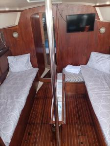 a small room with two beds and a flat screen tv at Nuit insolite sur un bateau in Le Barcarès