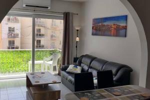 un soggiorno con divano e una grande finestra di Sunny Day Flat a San Pawl il-Baħar