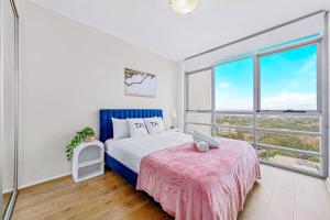 a bedroom with a bed and a large window at Stunning City and Water View Apartment in Sydney
