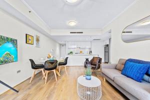 een woonkamer met een bank en een tafel bij Stunning City and Water View Apartment in Sydney