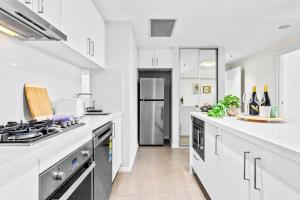 a kitchen with white cabinets and a stove top oven at Stunning City and Water View Apartment in Sydney